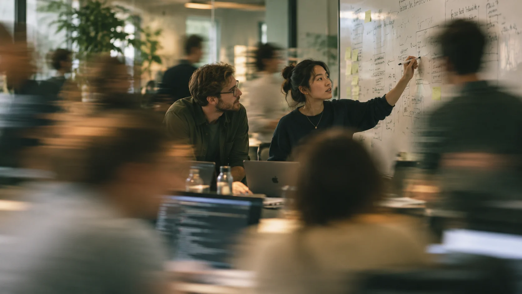 Colleagues working through a workflow at a whiteboard